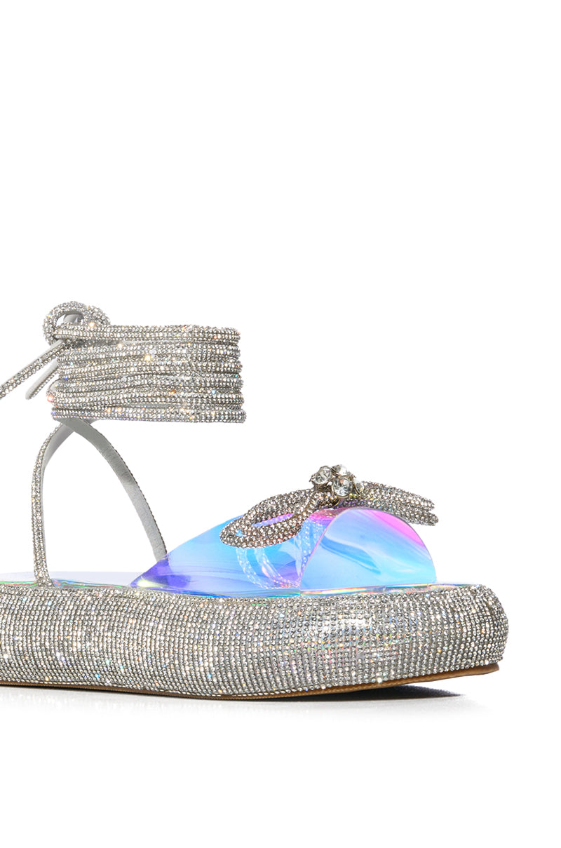 OUTSHINE EMBELLISHED BOW LACE UP FLAT SANDAL IN HOLO